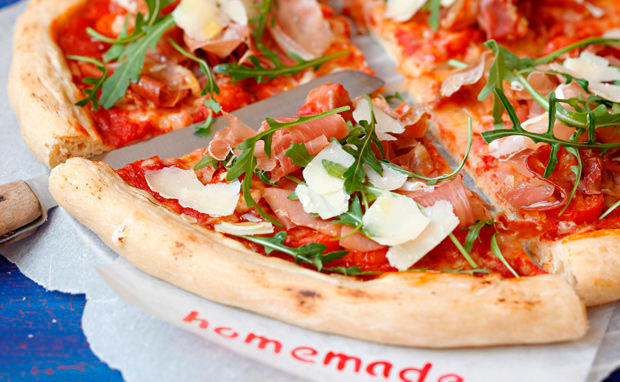 Pizza mit Schinken, Rucola und Parmesan