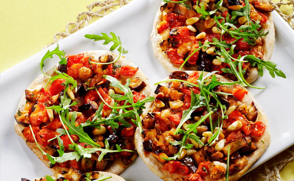 Mini-Pizzen mit Melanzani, Pignoli und Rucola