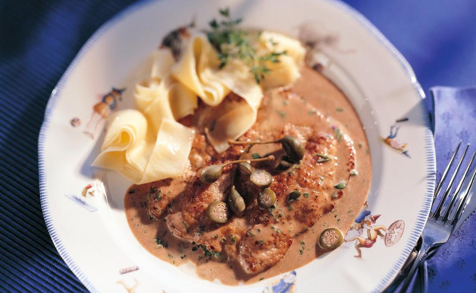 Gebratene Kalbsschnitzel mit Kapern-Rahmsauce und Bandnudeln