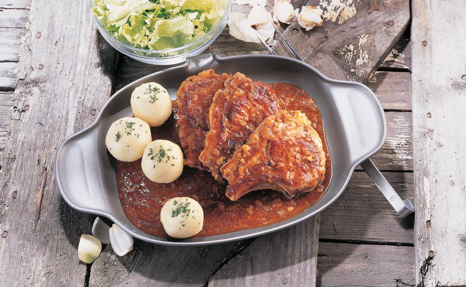 Schweinskoteletts mit Kümmelglace, Erdäpfelknödeln und Eisbergsalat